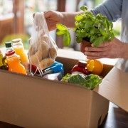Young man unpacking boxes of food at home